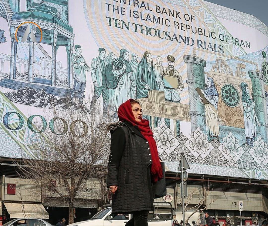 Une femme marche devant une fresque représentant un billet de dix mille rials de la Banque centrale de la République islamique.